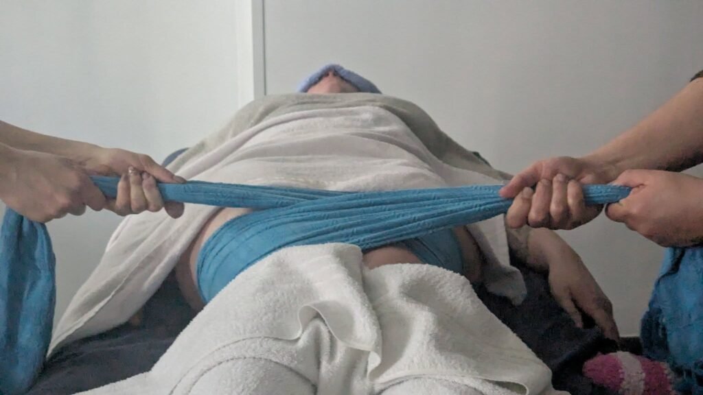 Soin rebozo réalisé par Mélissa, doula et accompagnante parentale, avec un tissu traditionnel pour envelopper et détendre une maman dans un moment de douceur.