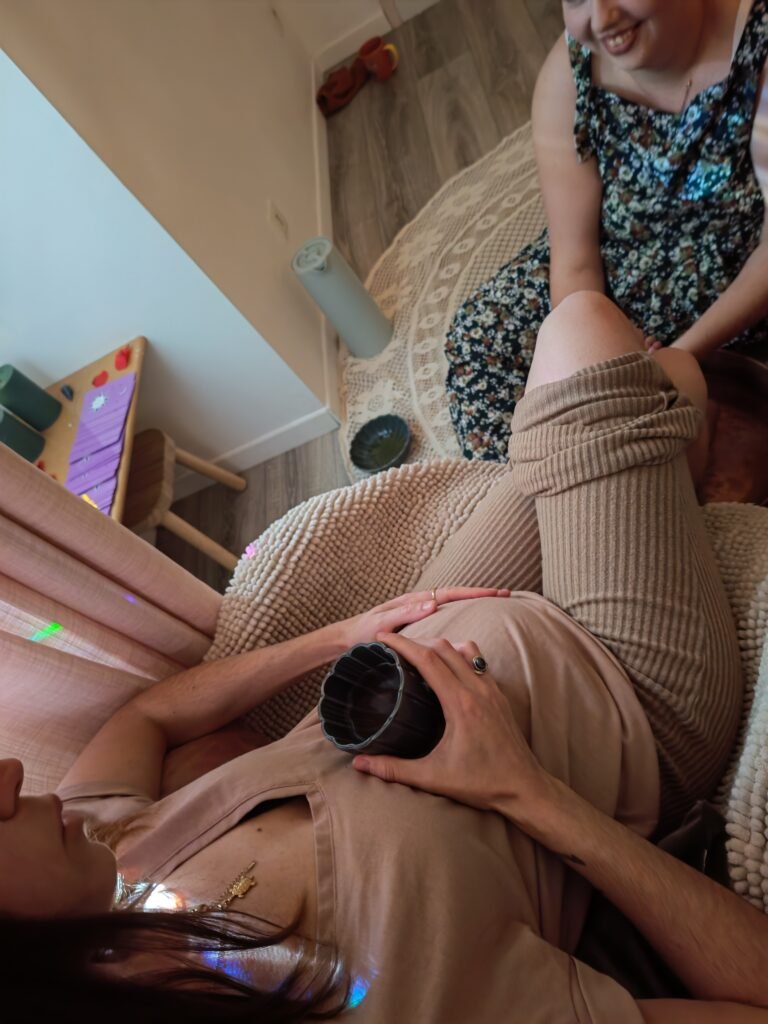 Femme enceinte posant ses mains sur son ventre, moment de connexion et de douceur pendant la grossesse