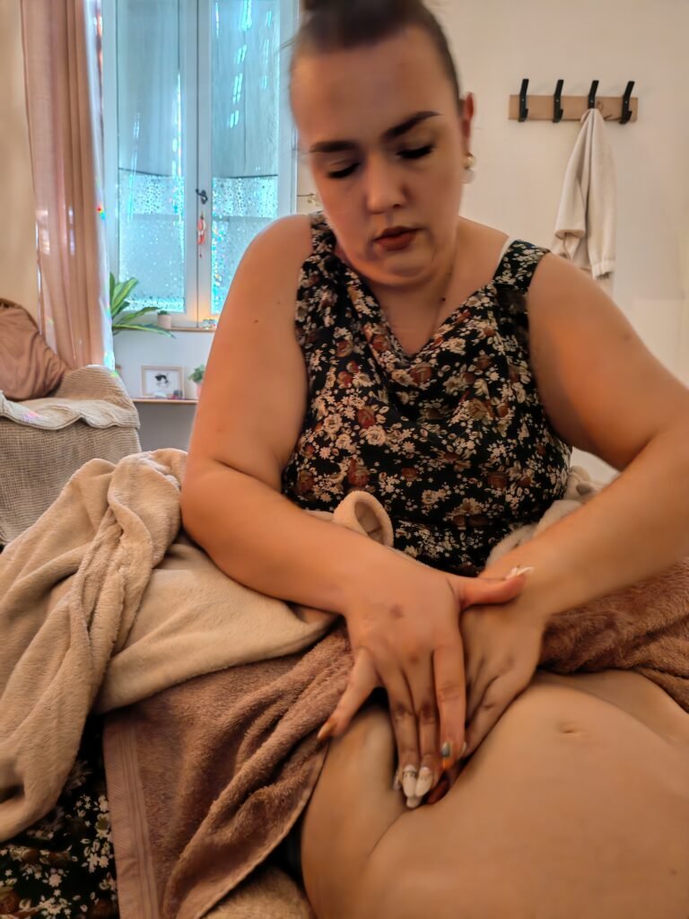 Praticienne réalisant un massage Sobada de l’utérus sur le ventre d’une femme pour soutenir la fertilité et le bien-être féminin